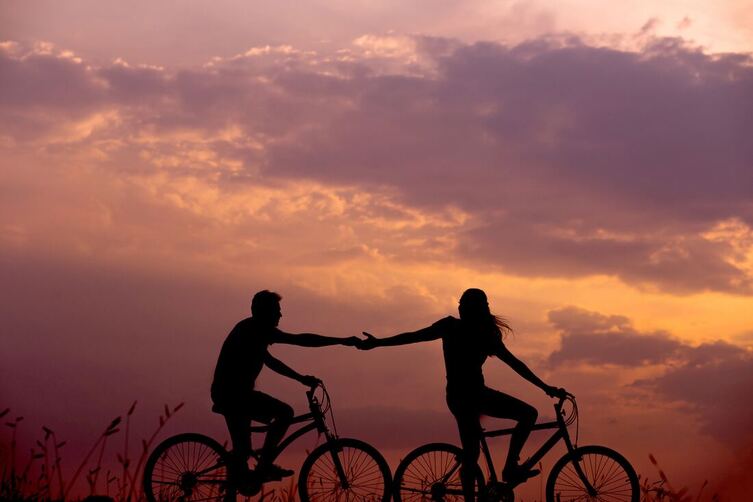 Biking couple sunset separating